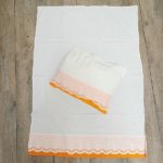 Vue d'ensemble de la parure bébé vintage, drap et taie d'oreiller à plat.
