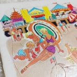 Gros plan sur le puzzle Playskool, montrant la découpe en carton et les couleurs éclatantes de la scène à la plage.